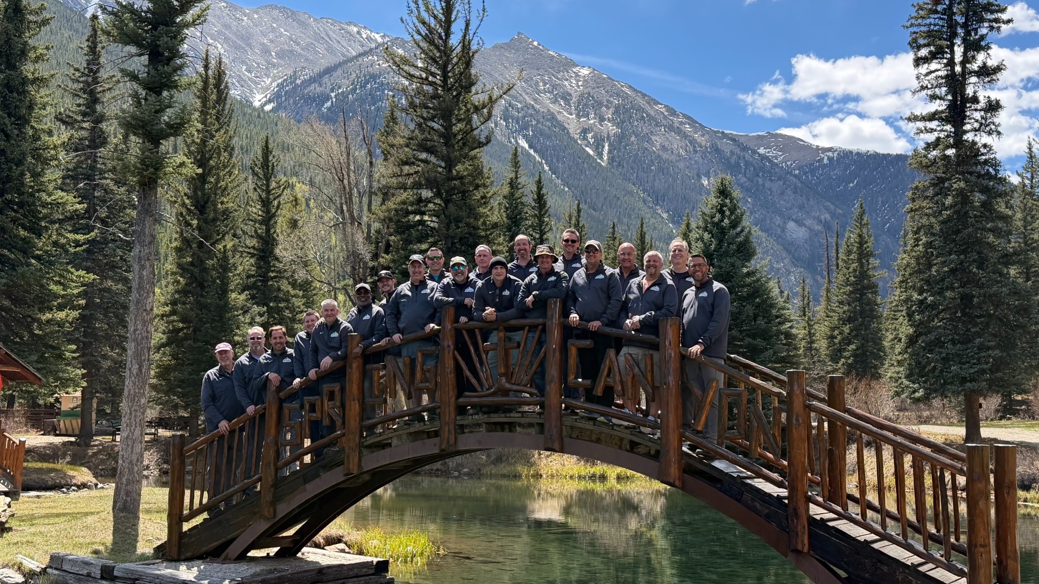 Members of the Lead Bulletproof Community gathered on a bridge in the Colorado mountains
